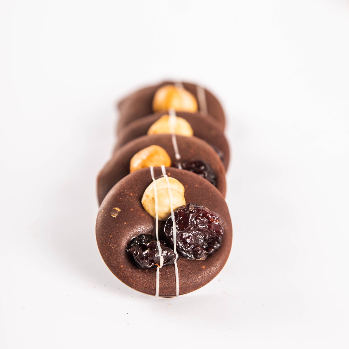 Mendiants with caramel and 72.5% dark chocolate, hazelnuts, cherries and basil